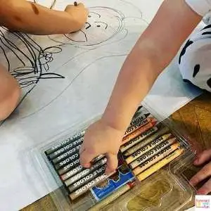 kids hands coloring in their life size portraits
