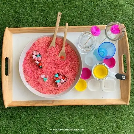 dyed rice sensory bin with pink rice and erasers