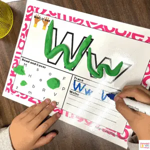 child writing letter Ww on W alphabet playdough mat