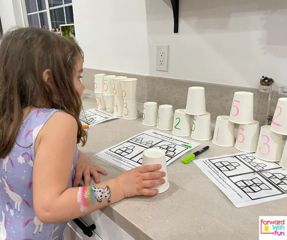 child doing the sums to 6 cups