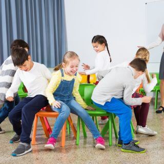 musical chairs in a school similar to hot potato with music and a person getting out each time