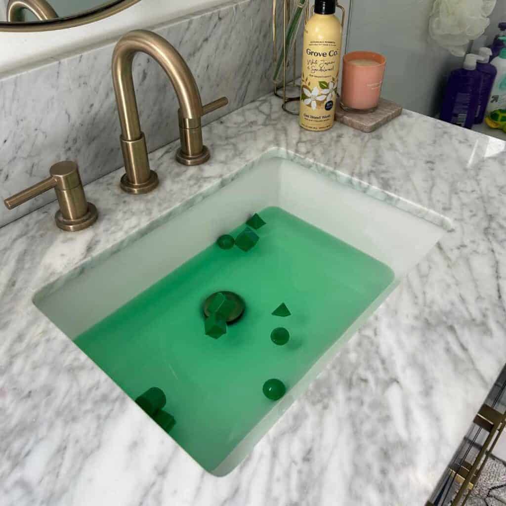 fun last minute leprechaun trick to play on kids at home with green food coloring and floating toys in the sink